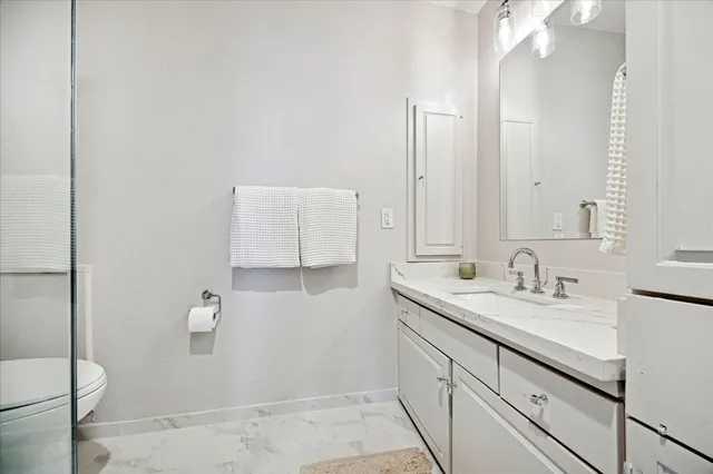 a bathroom with a granite countertop sink mirror and toilet