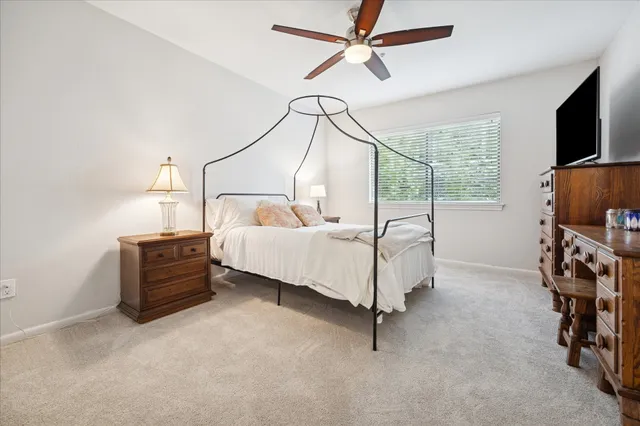 a bedroom with furniture a flat screen tv and a window