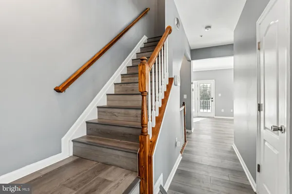 a view of a hallway with wooden floor and staircase