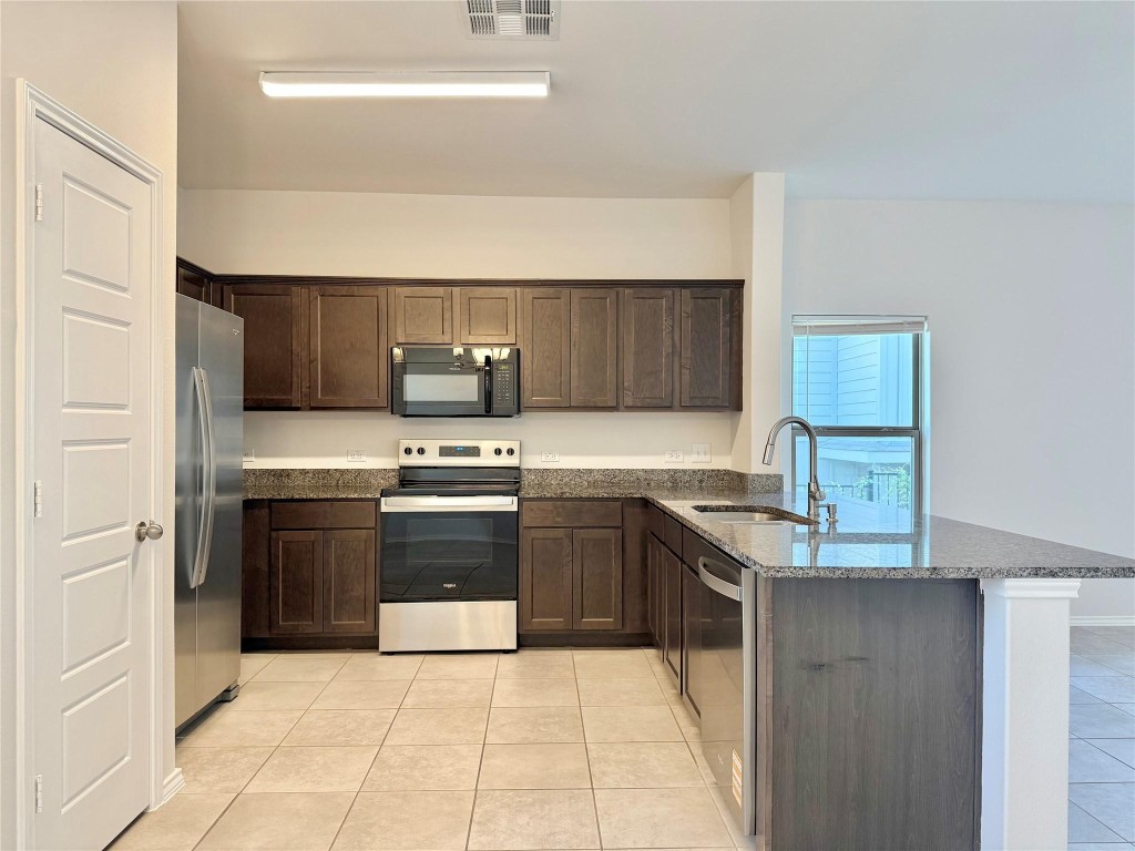 126 Dodge Road Georgetown, TX 78626 - Photo 7 of 18 a kitchen with stainless steel appliances granite countertop a stove and a refrigerator