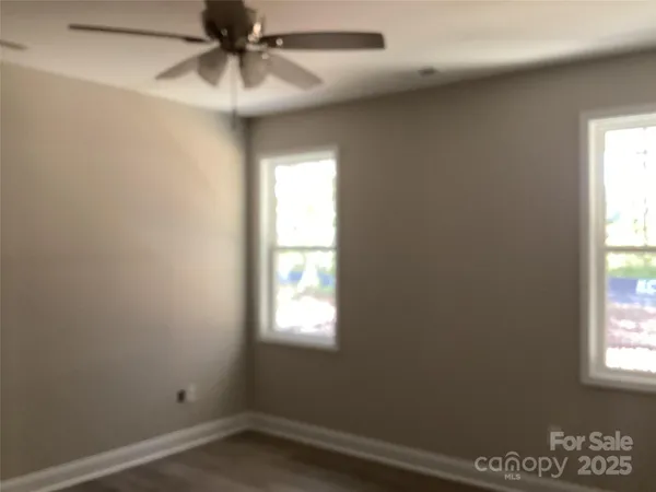 an empty room with a window and a fan