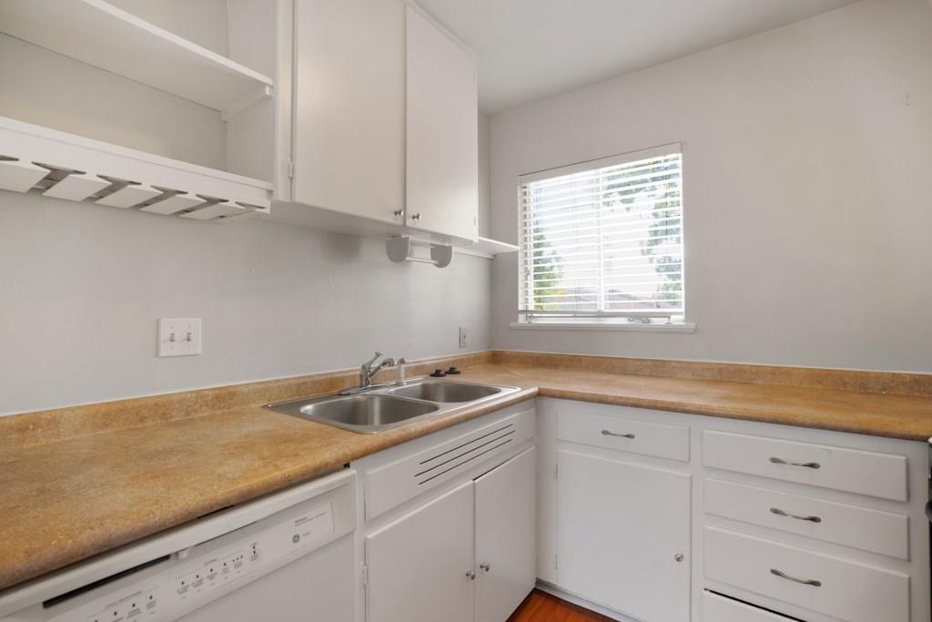 1311 Exposition Boulevard, Unit 8 Austin, TX 78703 - Photo 2 of 10 Kitchen featuring white cabinets, light countertops, and dishwasher