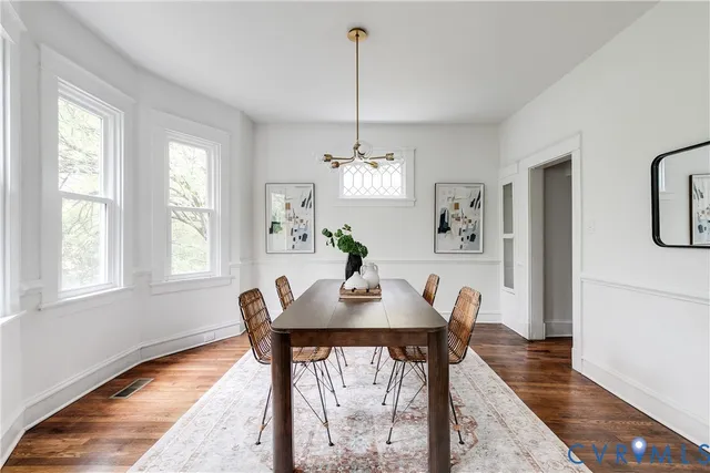 a dining room with furniture a chandelier and wooden floor