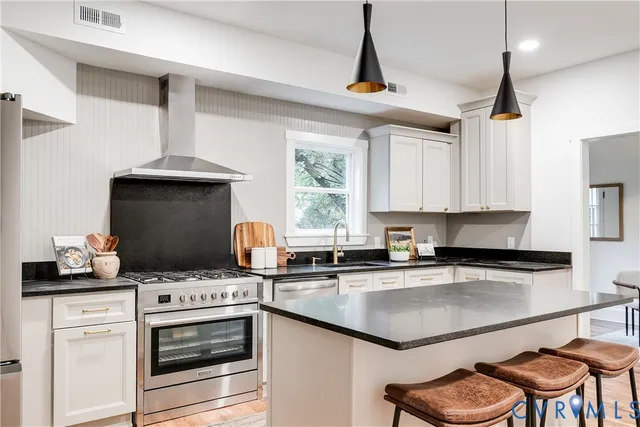 a kitchen with granite countertop a stove a sink and a microwave