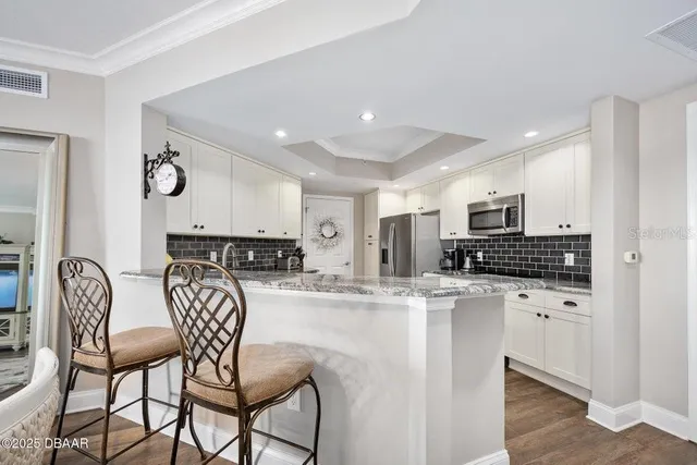 a kitchen with granite countertop white cabinets and white appliances