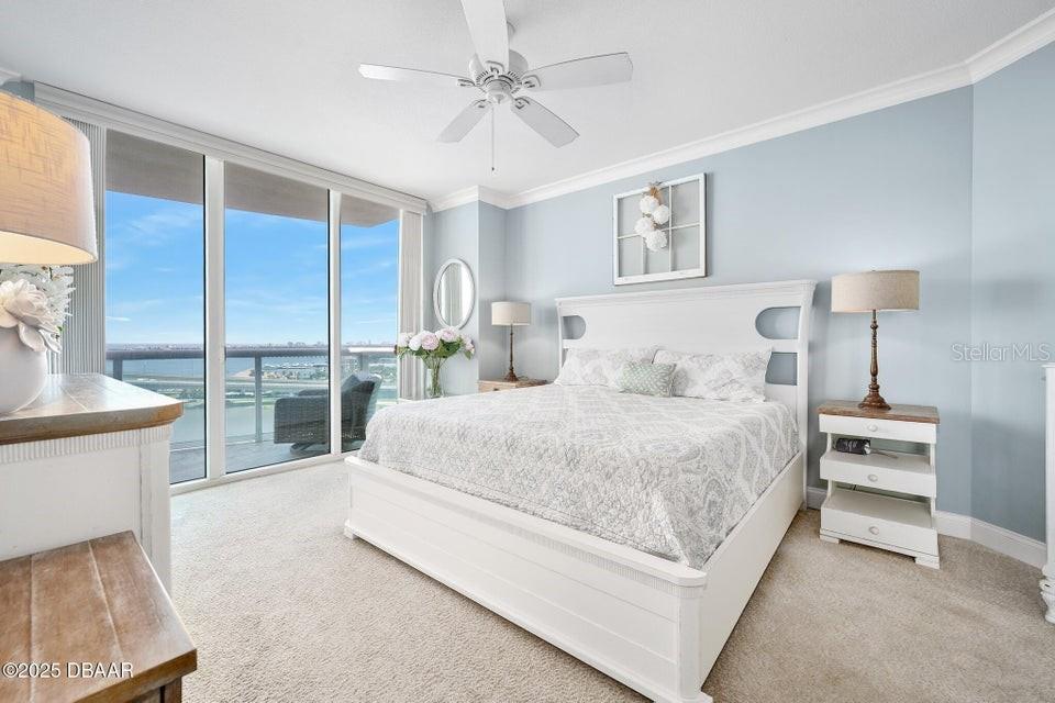 231 Riverside Drive, Unit 15071 Daytona Beach, FL 32117 - Photo 20 of 53 a bedroom with a large bed and a chandelier