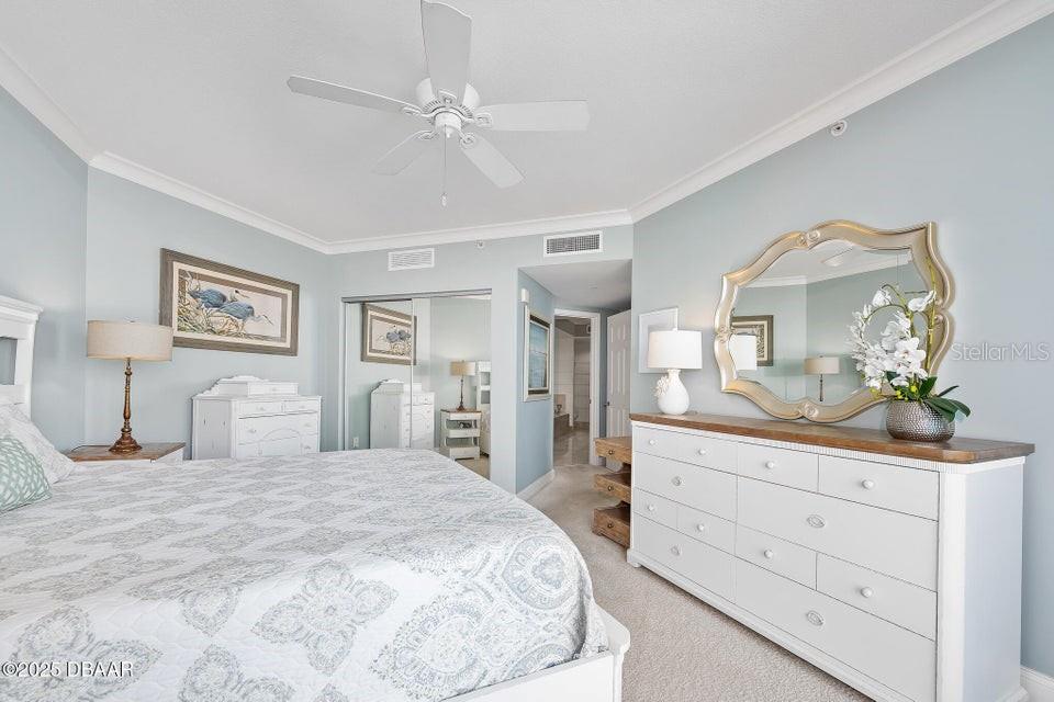 231 Riverside Drive, Unit 15071 Daytona Beach, FL 32117 - Photo 21 of 53 a bedroom with a large bed and a mirror on dresser