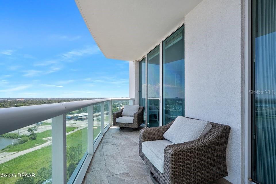 231 Riverside Drive, Unit 15071 Daytona Beach, FL 32117 - Photo 22 of 53 a balcony with furniture and a garden