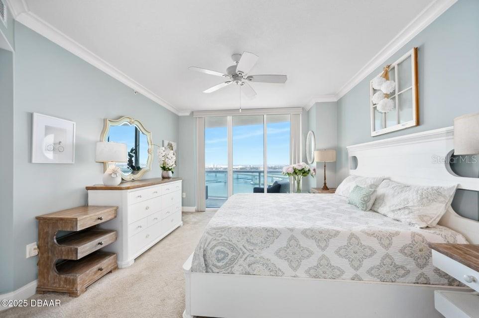 231 Riverside Drive, Unit 15071 Daytona Beach, FL 32117 - Photo 23 of 53 a bedroom with a large bed and a chandelier