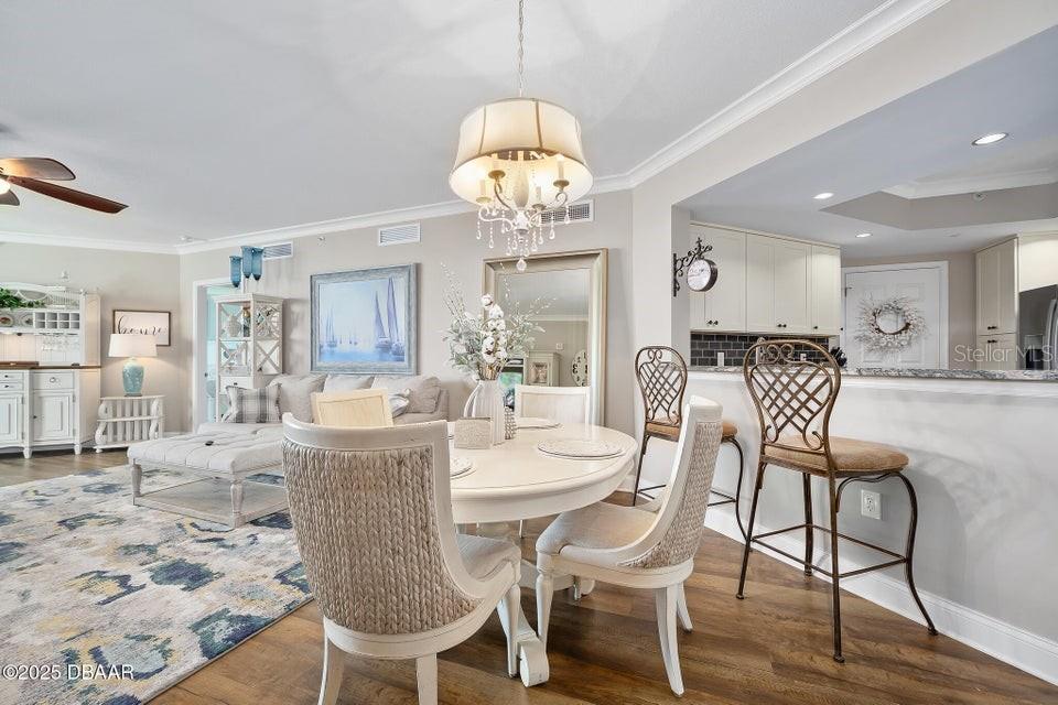 231 Riverside Drive, Unit 15071 Daytona Beach, FL 32117 - Photo 7 of 53 a view of a dining room with furniture wooden floor and chandelier