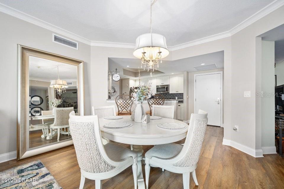 231 Riverside Drive, Unit 15071 Daytona Beach, FL 32117 - Photo 8 of 53 a view of a dining room with furniture wooden floor and chandelier