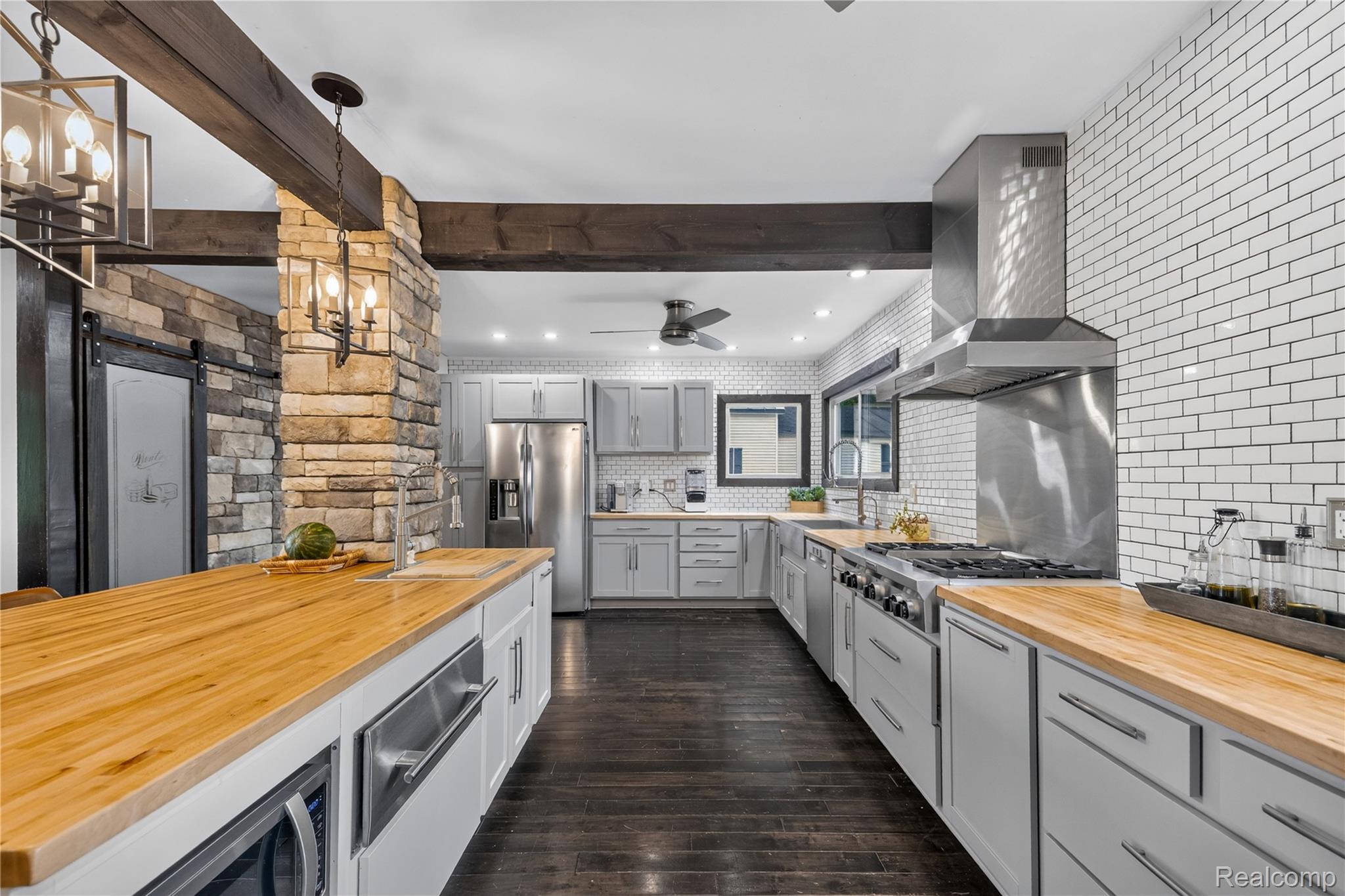 4860 Blue Bush Road Monroe, MI 48162 - Photo 9 of 59 Kitchen featuring butcher block countertops, white subway tile backsplash, stainless steel appliances, dark wood-finish flooring, and exposed ceiling beams