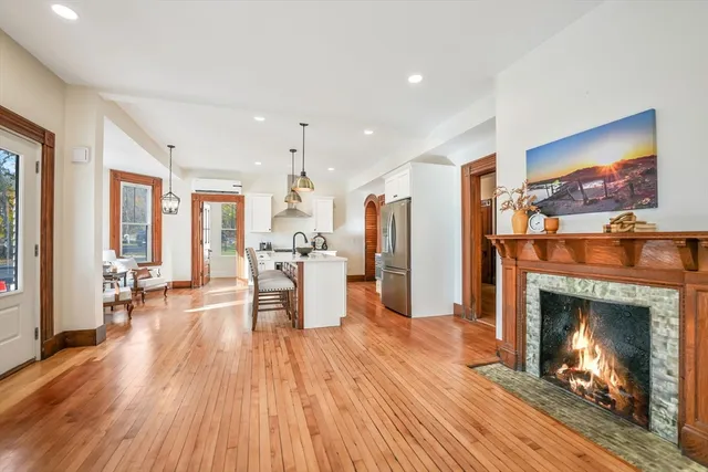 a kitchen with stainless steel appliances a dining table chairs stove and wooden floor