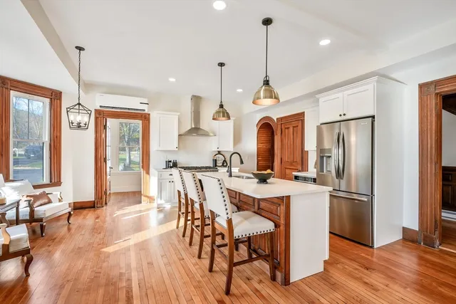 a view of a dining room and livingroom with furniture wooden floor a chandelier