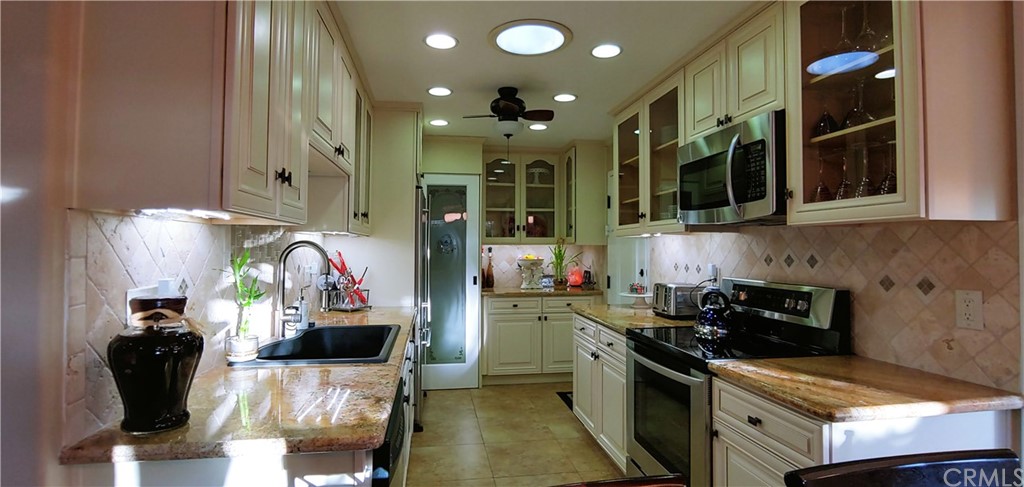 a kitchen with stainless steel appliances kitchen island granite countertop a stove and cabinets