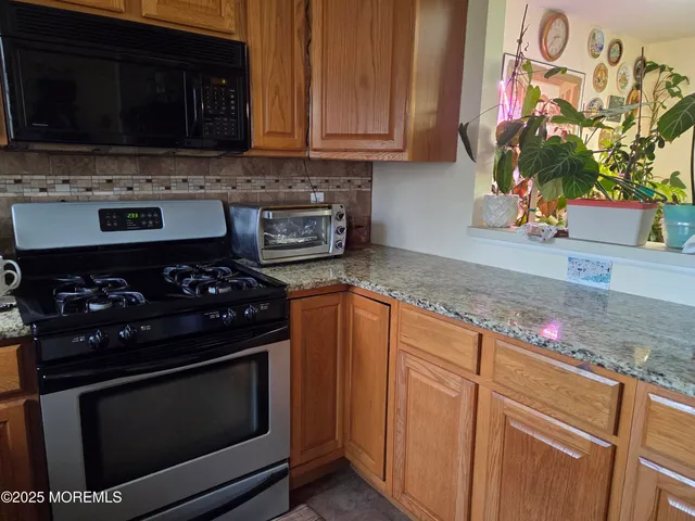 a kitchen with stainless steel appliances a stove a microwave a sink and cabinets
