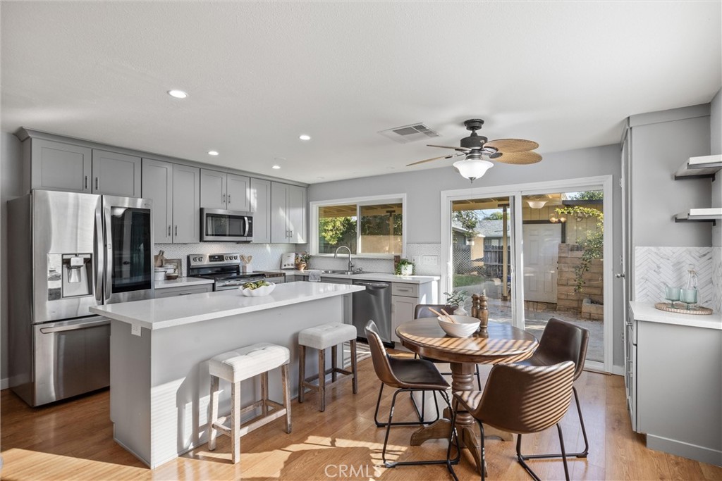 1 Parkhurst Street Chico, CA 95928 - Photo 7 of 52 a kitchen with stainless steel appliances a dining table chairs stove refrigerator and cabinets
