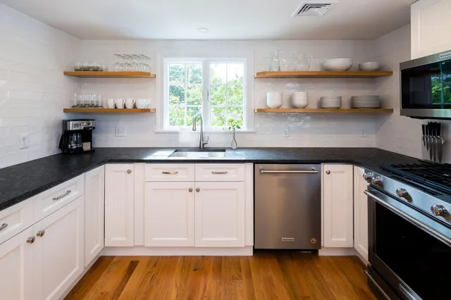 a kitchen with stainless steel appliances granite countertop a sink and a stove top oven