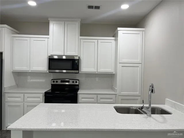 a kitchen with a refrigerator and white cabinets