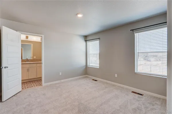 an empty room with windows and closet