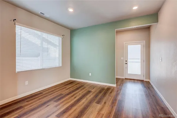 a view of a room with wooden floor and a window