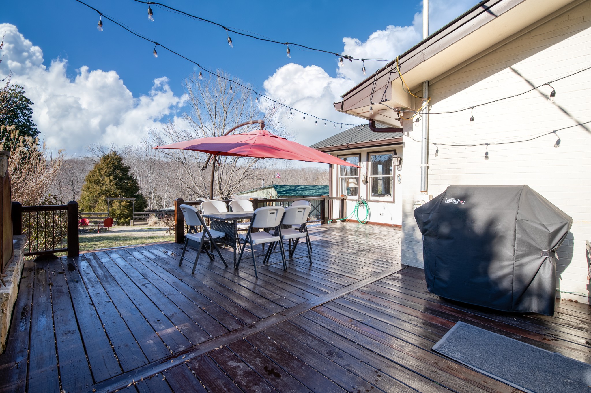 7515 Pewitt Road Franklin, TN 37064 - Photo 57 of 96 a view of a roof deck with table and chairs under an umbrella with wooden floor