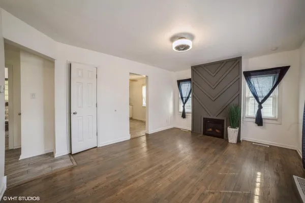 an empty room with wooden floor and a fireplace