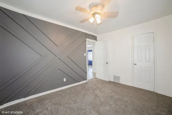 a view of a livingroom with an empty space and a ceiling fan