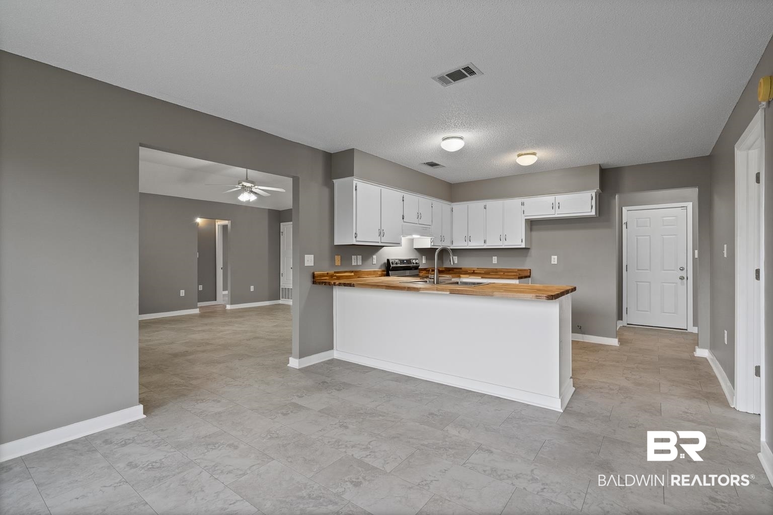 16418 Avent Lane Foley, AL 36535 - Photo 12 of 30 Kitchen with white cabinetry, kitchen peninsula, a textured ceiling, ceiling fan, and sink