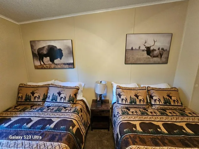 a bedroom with two beds and painting on the wall