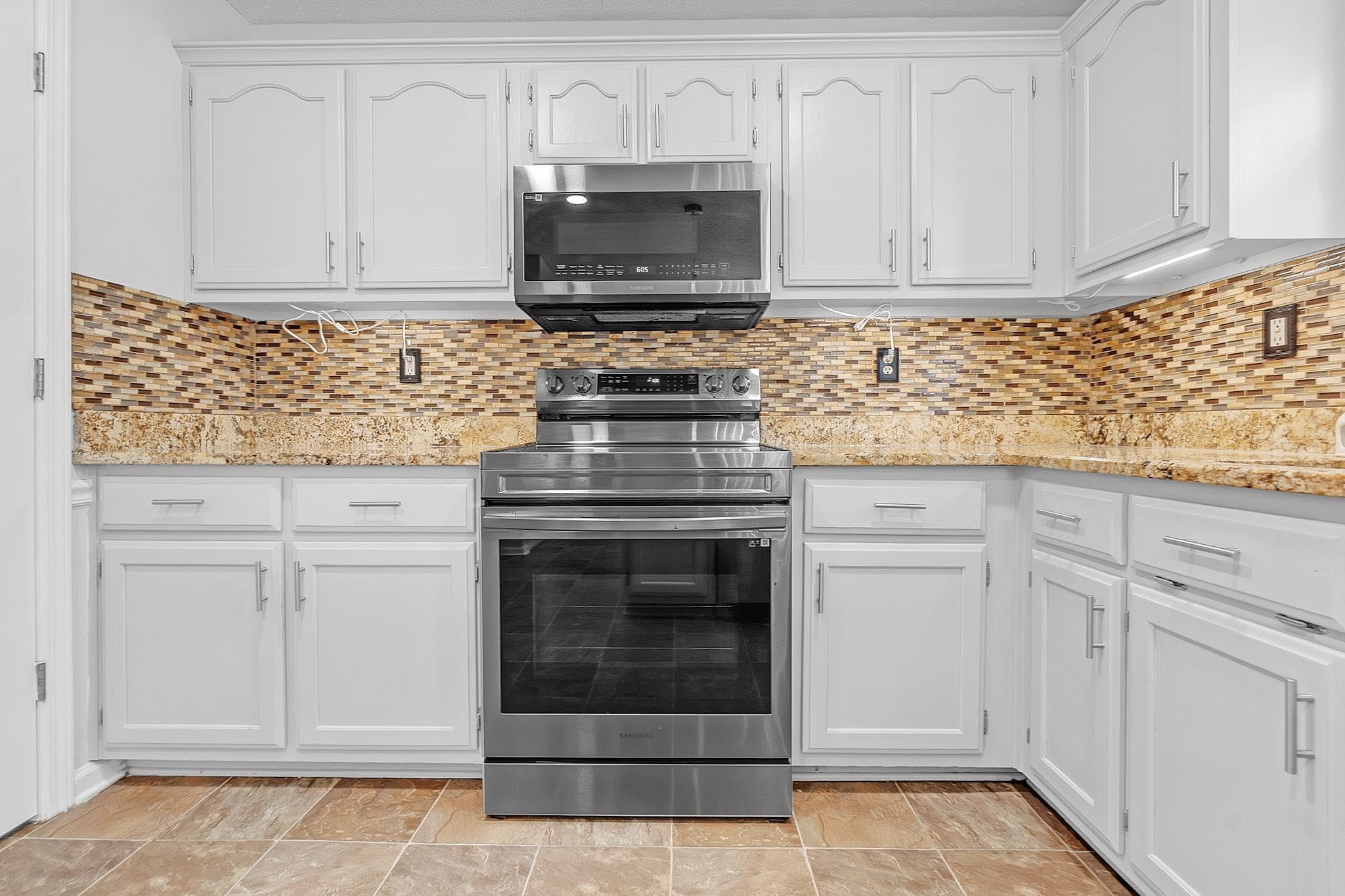 4788 Shadow View Lane Bartlett, TN 38002 - Photo 12 of 33 Kitchen with stainless steel appliances, white cabinets, and decorative backsplash