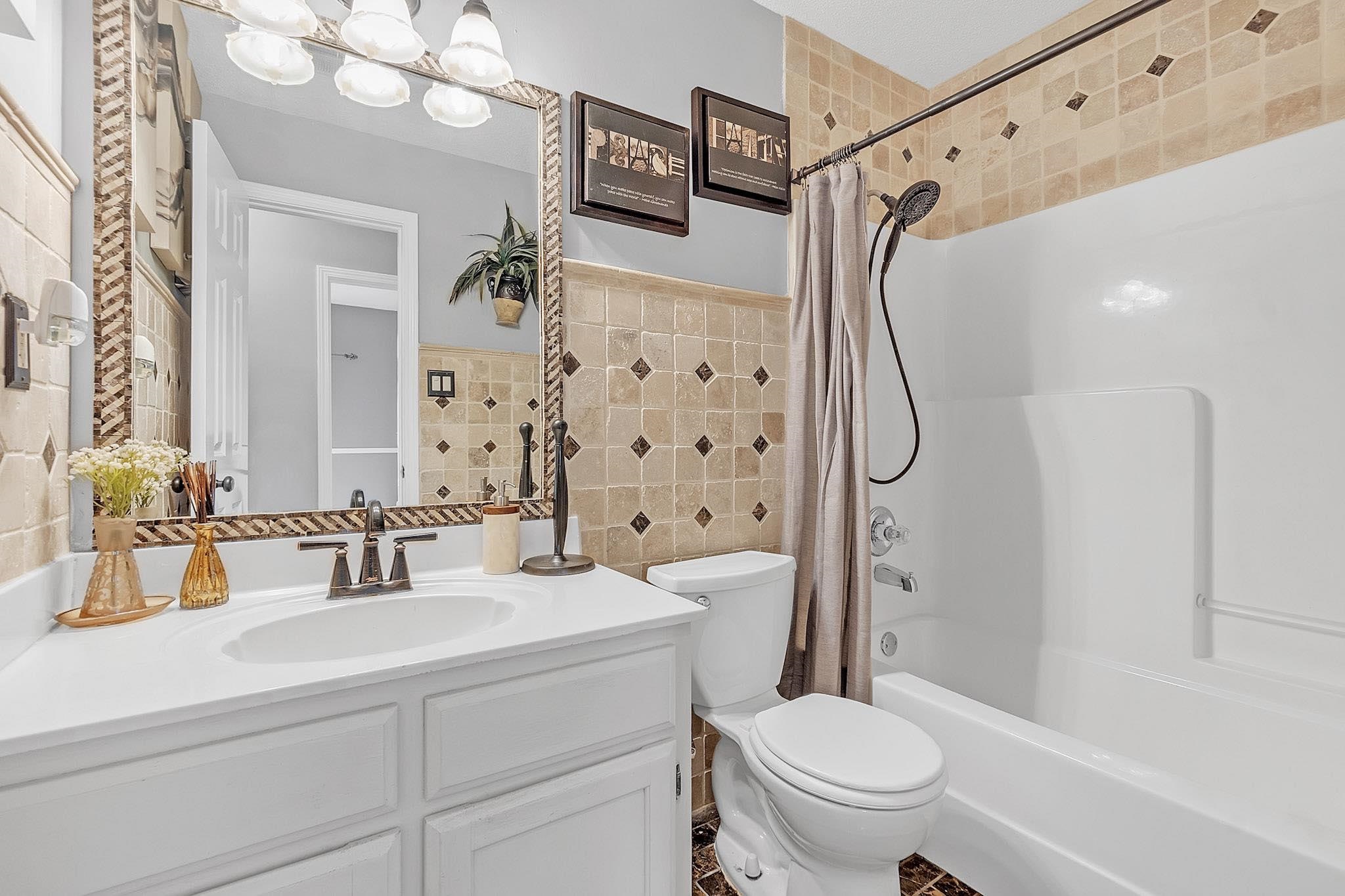 4788 Shadow View Lane Bartlett, TN 38002 - Photo 25 of 33 Full bath with tile walls, vanity, shower / bath combo with shower curtain, and toilet