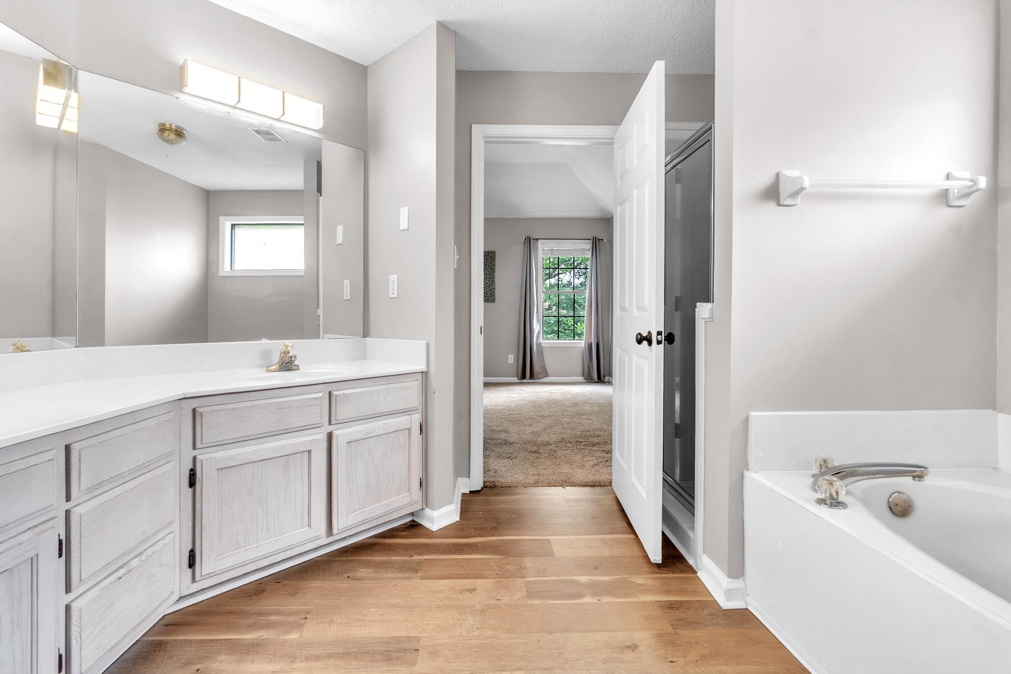 4788 Shadow View Lane Bartlett, TN 38002 - Photo 30 of 33 Full bathroom featuring vanity, wood finished floors, a garden tub, and healthy amount of natural light