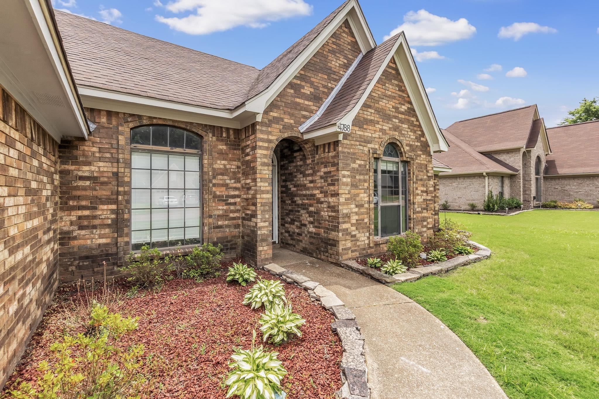 4788 Shadow View Lane Bartlett, TN 38002 - Photo 5 of 33 View of exterior entry with brick siding, a lawn, and roof with shingles