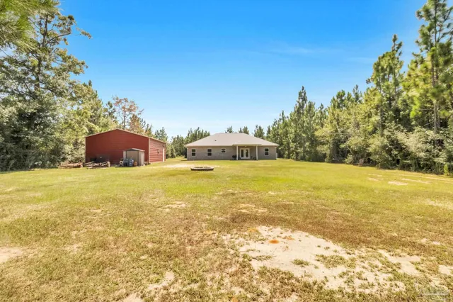 a front view of house with yard and trees in the background