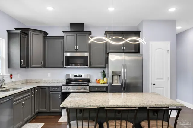 a spacious bedroom with a bed a dresser and a flat screen tv