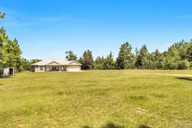 a view of a house with a yard and garage