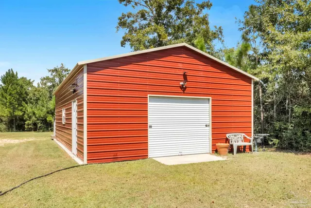 a front view of house with yard and trees in the background