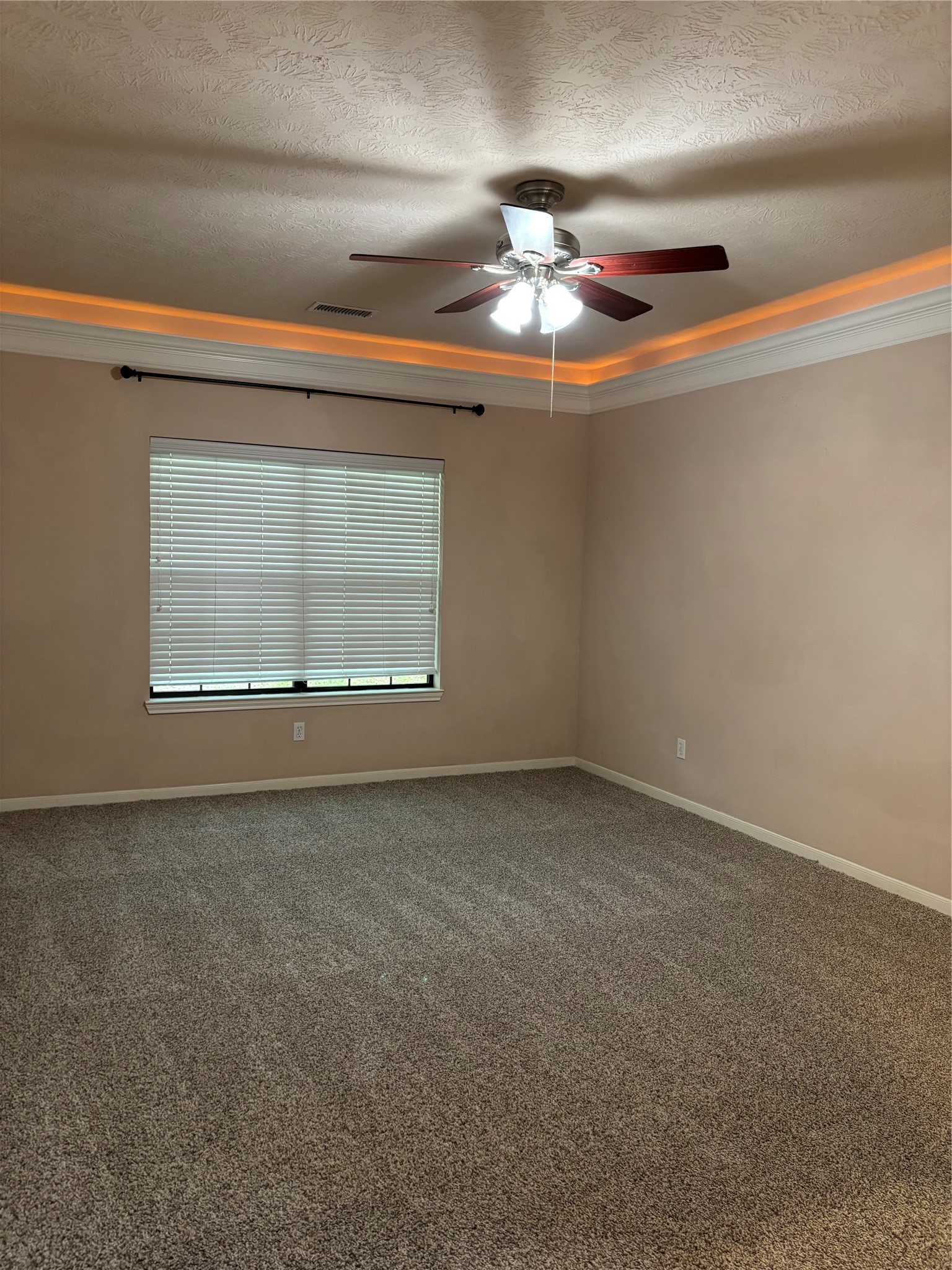 3238 Glenforest Road Montgomery, TX 77356 - Photo 19 of 41 Primary bedroom with neutral walls, a plush carpet, and a ceiling fan with lights. It has a window with blinds and crown molding with recessed lighting, creating a cozy atmosphere.