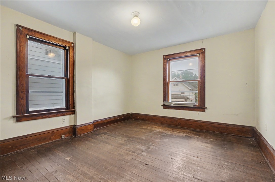 456 Delmar Avenue Akron, OH 44310 - Photo 20 of 27 Room featuring two windows with wood trim, wood baseboards, and wood-finish flooring