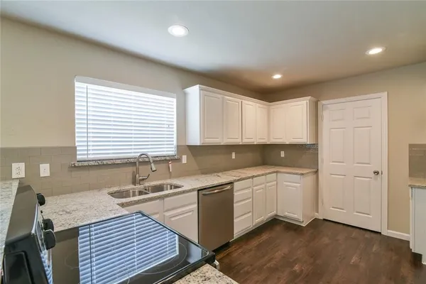 a kitchen with a sink stove and cabinets