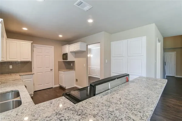 a spacious bathroom with a granite countertop sink and a refrigerator