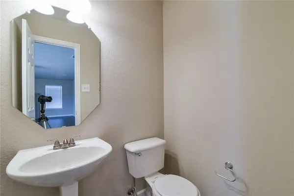 a bathroom with a toilet a sink and mirror