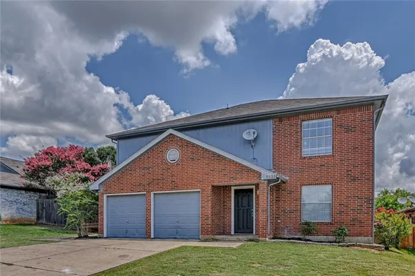 a front view of a house with a yard and a garage