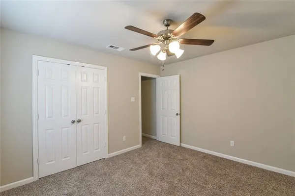 an empty room with a ceiling fan and a window