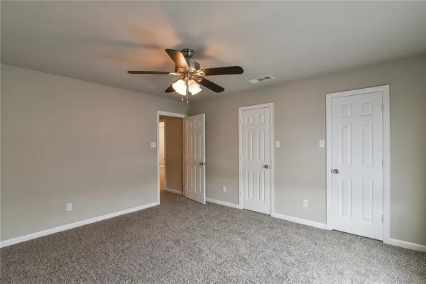 a view of an empty room with a chandelier fan