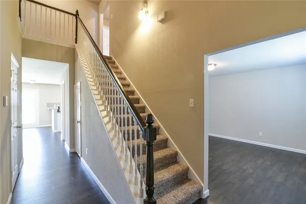 a view of a hallway with wooden floor and staircase
