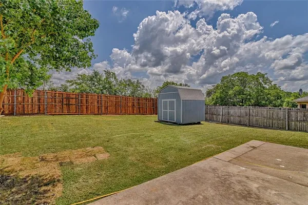 a view of a backyard with brick wall and wooden fence
