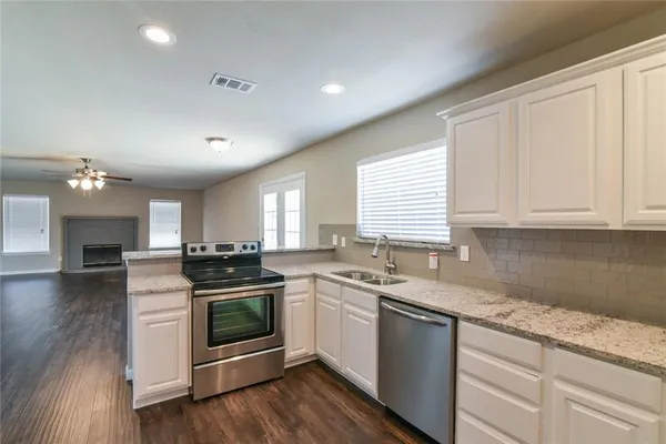 a kitchen with a stove sink and cabinets