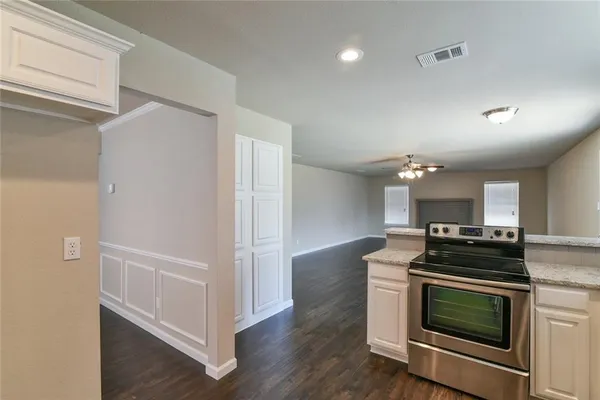 a kitchen with granite countertop a stove and a refrigerator